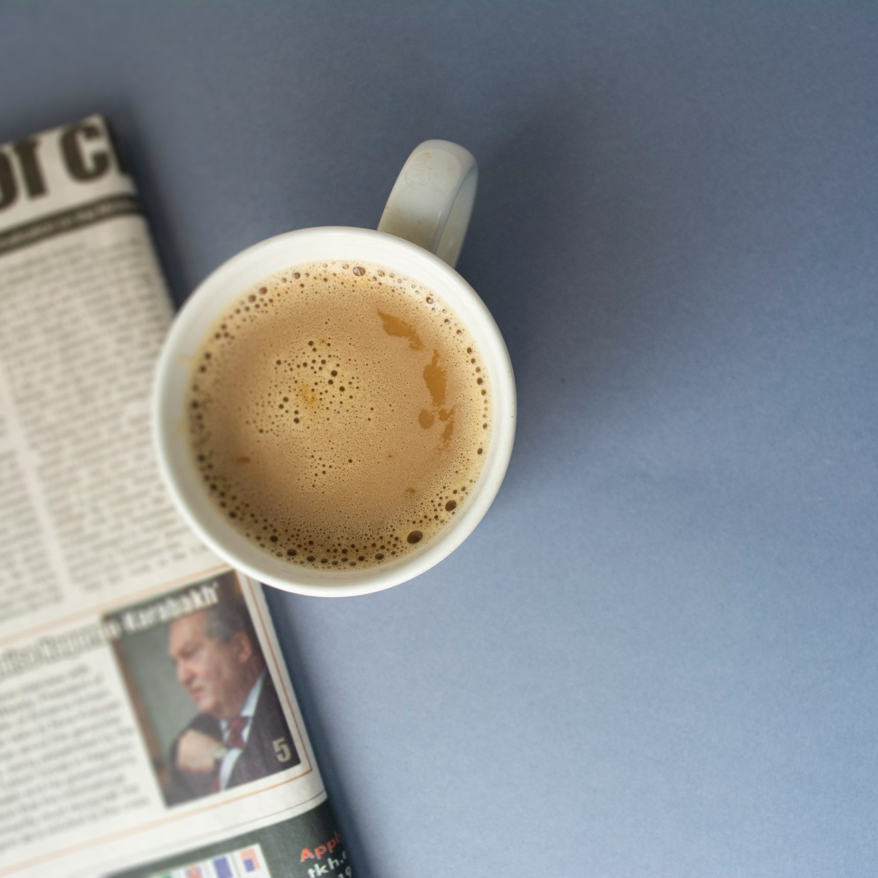 Tageszeitung auf einem Tisch mit einer Tasse Kaffee. Doch wie kommt man in die Zeitung?