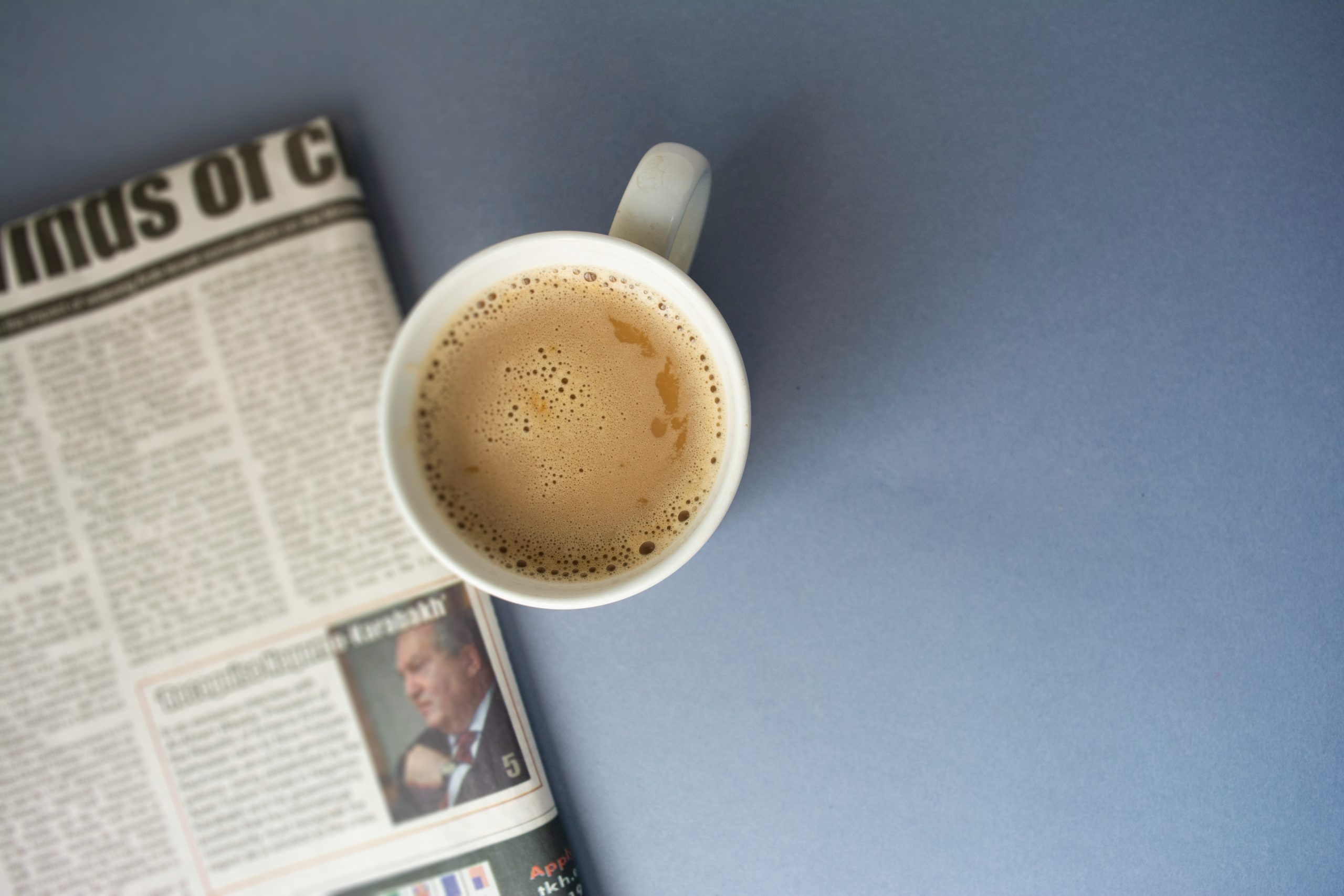 Tageszeitung auf einem Tisch mit einer Tasse Kaffee. Doch wie kommt man in die Zeitung?